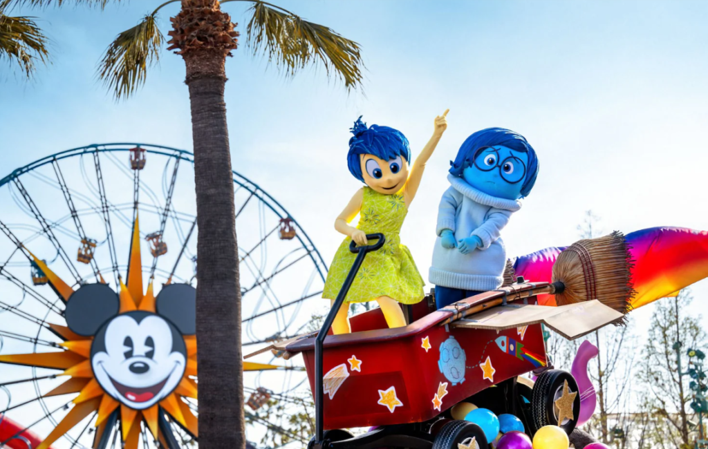 Joy and Sadness from Inside Out posing at the new Disney parade.